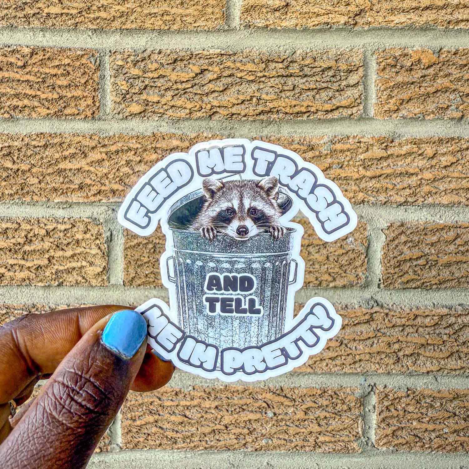 Trash panda sticker that reads "Feed me trash and tell me I'm pretty"
